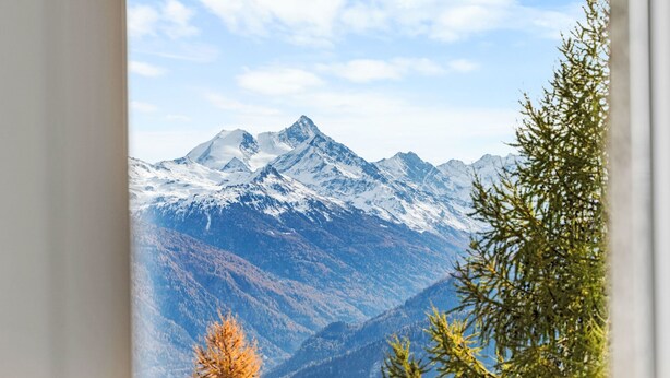Un paisaje montañoso con picos nevados y un cielo despejado.