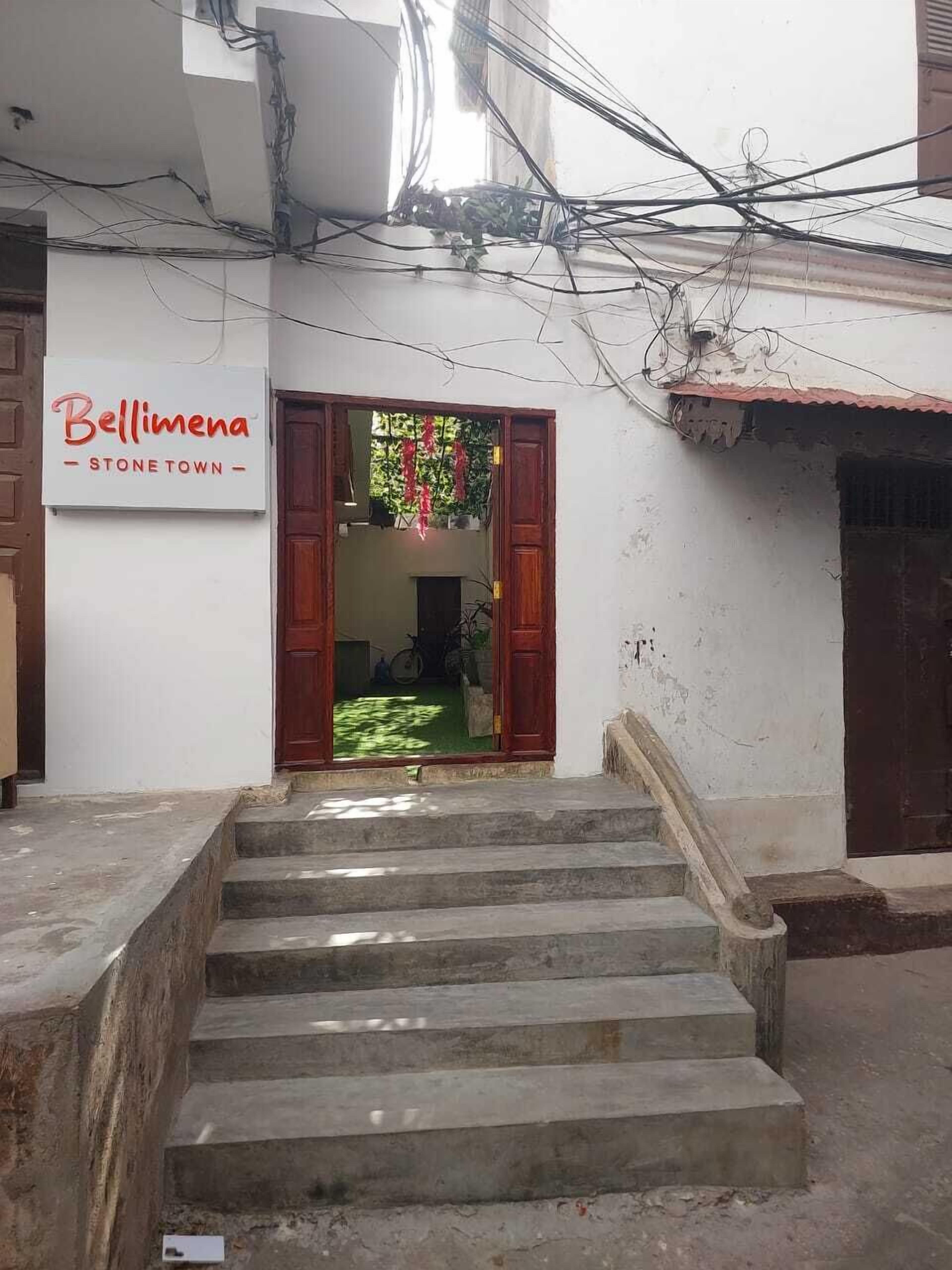 Une entrée d’immeuble avec un escalier menant à une porte.