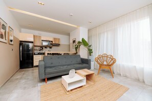 Departamento, cocineta, vista a la ciudad | Área de sala de estar | Smart TV de 55 pulgadas con canales digitales y servicios de streaming 