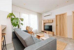 Apartamento, 2 quartos, vista para a cidade | Área de estar | Smart TV 55 polegadas com canais digitais, serviços de streaming