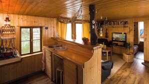 Ein Holzblockhaus-Innenraum mit Küche, Essbereich und Wohnzimmer.
