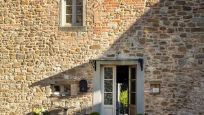 A stone building with a bell tower, a door, and a small window. - Town house with garden in charming Tuscan hilltop village (San Pancrazio)