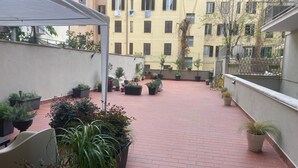 A rooftop terrace with potted plants and a brick floor. - ULIVO GUEST HOUSE ROME (Rome)