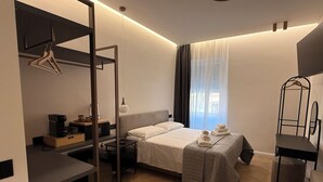A modern hotel room with a bed, bedside table, and a desk with a chair. - ULIVO GUEST HOUSE ROME (Rome)
