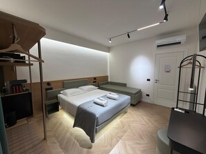Une chambre à coucher moderne, comprenant un lit, des tables de chevet, un bureau et une armoire suspendue.