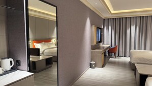 A modern hotel room with a bed, a desk, a chair, a television, and a mirror. - Amaris Hotel (Barka)