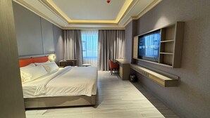 A hotel room with a large bed, a desk, a television, and a view of the outdoors. - Amaris Hotel (Barka)
