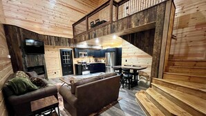 Un intérieur de chalet chaleureux comprenant un espace de vie, une cuisine et un coin repas.