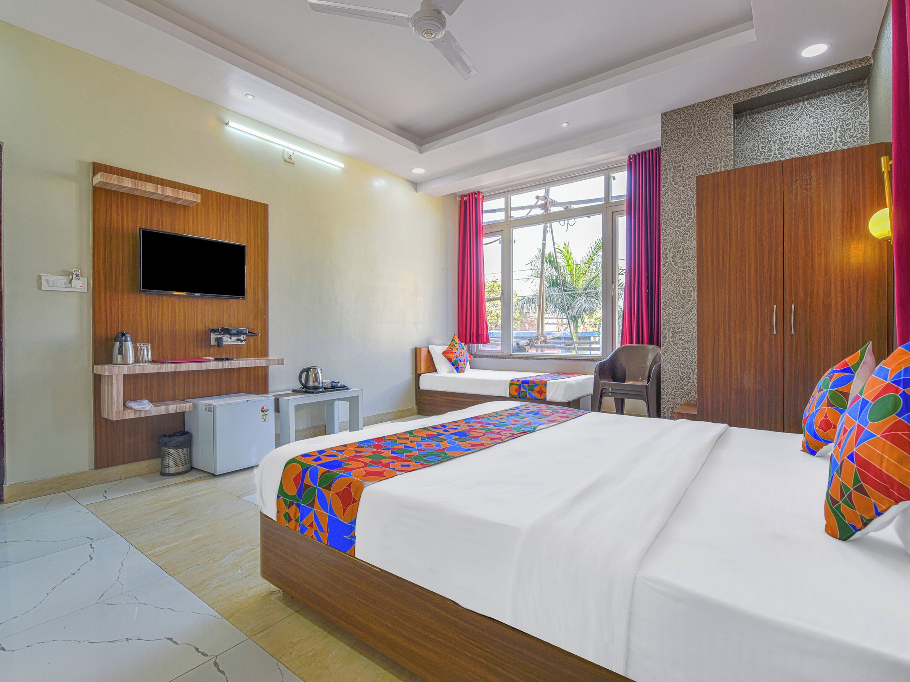 A hotel room with a bed, a desk, a TV, and a wardrobe.