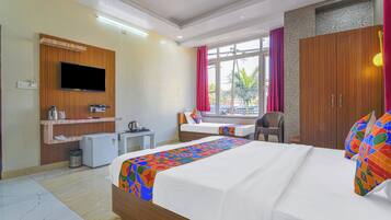 Ein Hotelzimmer mit Bett, Schreibtisch, Fernseher und Kleiderschrank.