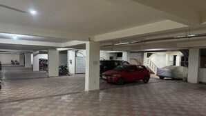 Un aparcamiento de varios niveles, con un coche rojo estacionado en la planta baja.