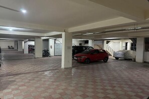 Un aparcamiento de varios niveles, con un coche rojo estacionado en la planta baja.