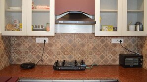 A kitchen with a gas stove, a toaster, and cabinets with glass doors.