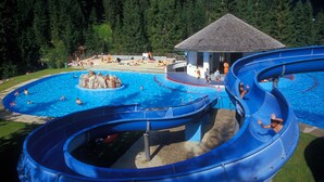 Parque acuático con múltiples toboganes y una zona de piscina central.