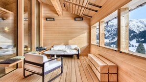 Un interior de madera con un sofá, sillas y una mesa.
