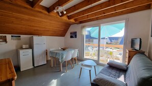 Un espacio habitable compacto con kitchenette, comedor y sofá.