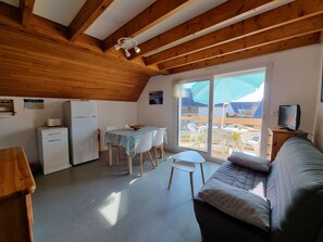 A compact living space with a kitchenette, dining area, and a sofa. - Duplex T3 apartment near beach and port, private parking, pets allowed (Sarzeau)