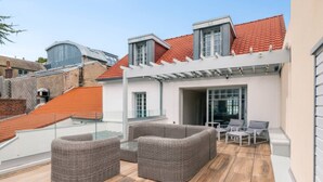 A rooftop patio with wicker furniture, a pergola, and a view of neighboring buildings. - Villa in Central Le Touquet with Air Conditioning and Wifi (Le Touquet-Paris-Plage)