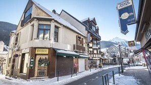Una calle cubierta de nieve con un edificio que dice "ENTREE" y un letrero que anuncia "DISCO THEQUE SNACK exotique CLUB".