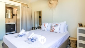 Ein Hotelzimmer mit Bett, Badezimmer, Spiegel und einem kleinen Tisch.