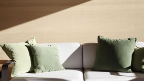 A modern living room with a white sofa and two green cushions. - Haus Obdr Lech in Lech (Lech am Arlberg)