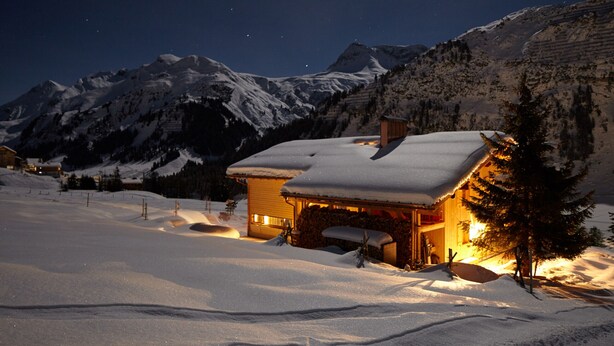 A snow-covered mountain landscape at night with a lit cabin. - Haus Obdr Lech in Lech (Lech am Arlberg)