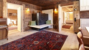 A rustic wooden interior with a large rug, wooden furniture, and a piano. - Haus Obdr Lech in Lech (Lech am Arlberg)
