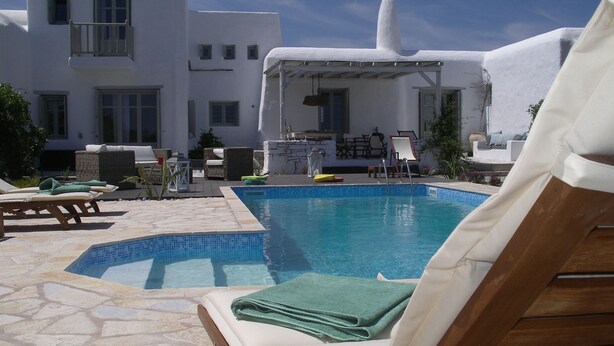 A pool area with lounge chairs and a covered seating area. - House with private pool (Kamares Naousas)