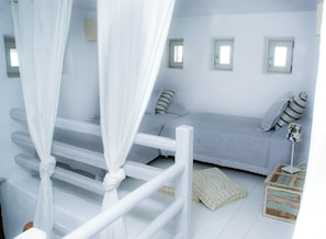 Ein Schlafzimmer mit Bett, Nachttisch, Fenster und Vorhang.