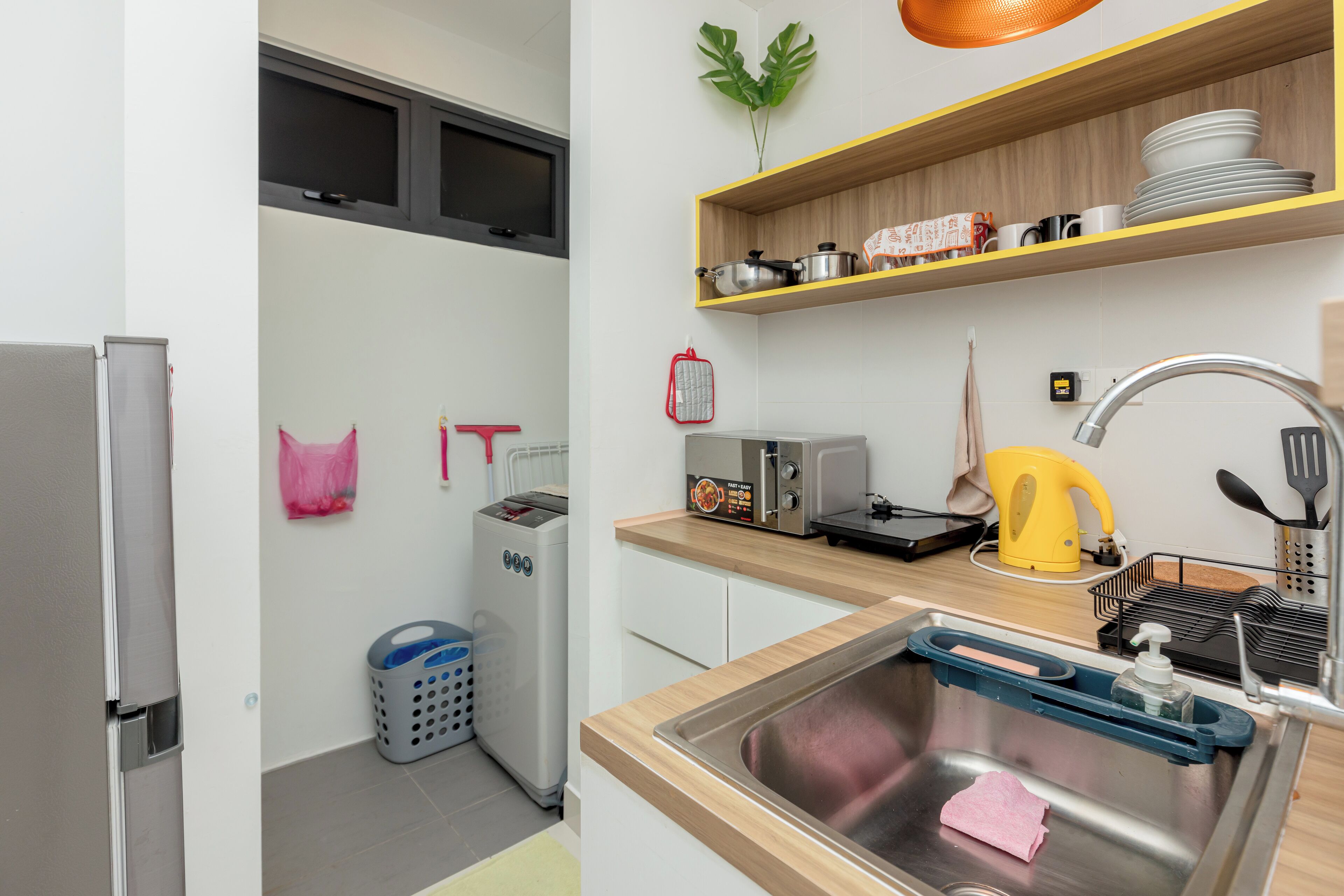A modern kitchen with a stainless steel sink, a toaster, and a kettle.