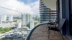 A balcony with a curved glass railing, a wooden floor, and a table with chairs. - ArteS Suite Penang (George Town)