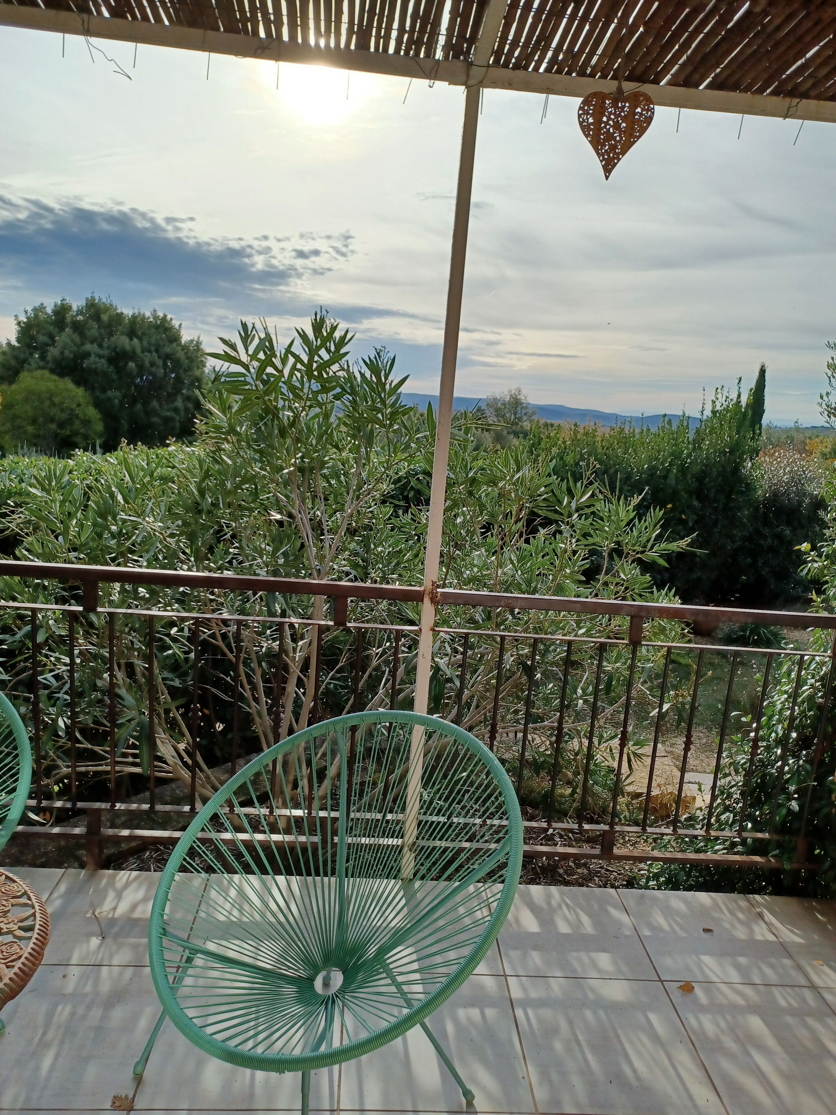 Un espacio al aire libre cubierto con vistas a un jardín y colinas lejanas.