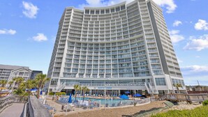 A multi-story hotel with a pool area, outdoor seating, and a sign reading 'North Tower.'