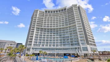Un hotel de varios pisos con área de piscina, asientos al aire libre y un letrero que dice 'North Tower'.