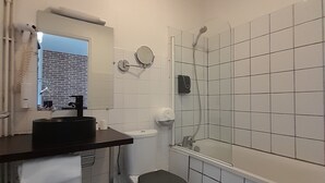 Une salle de bain équipée de toilettes, d’un lavabo, d’un miroir et d’une douche.