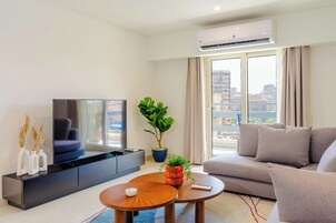 Apartamento, balcón, vistas a la ciudad | Zona de estar | Smart TV de 55 pulgadas con canales digitales