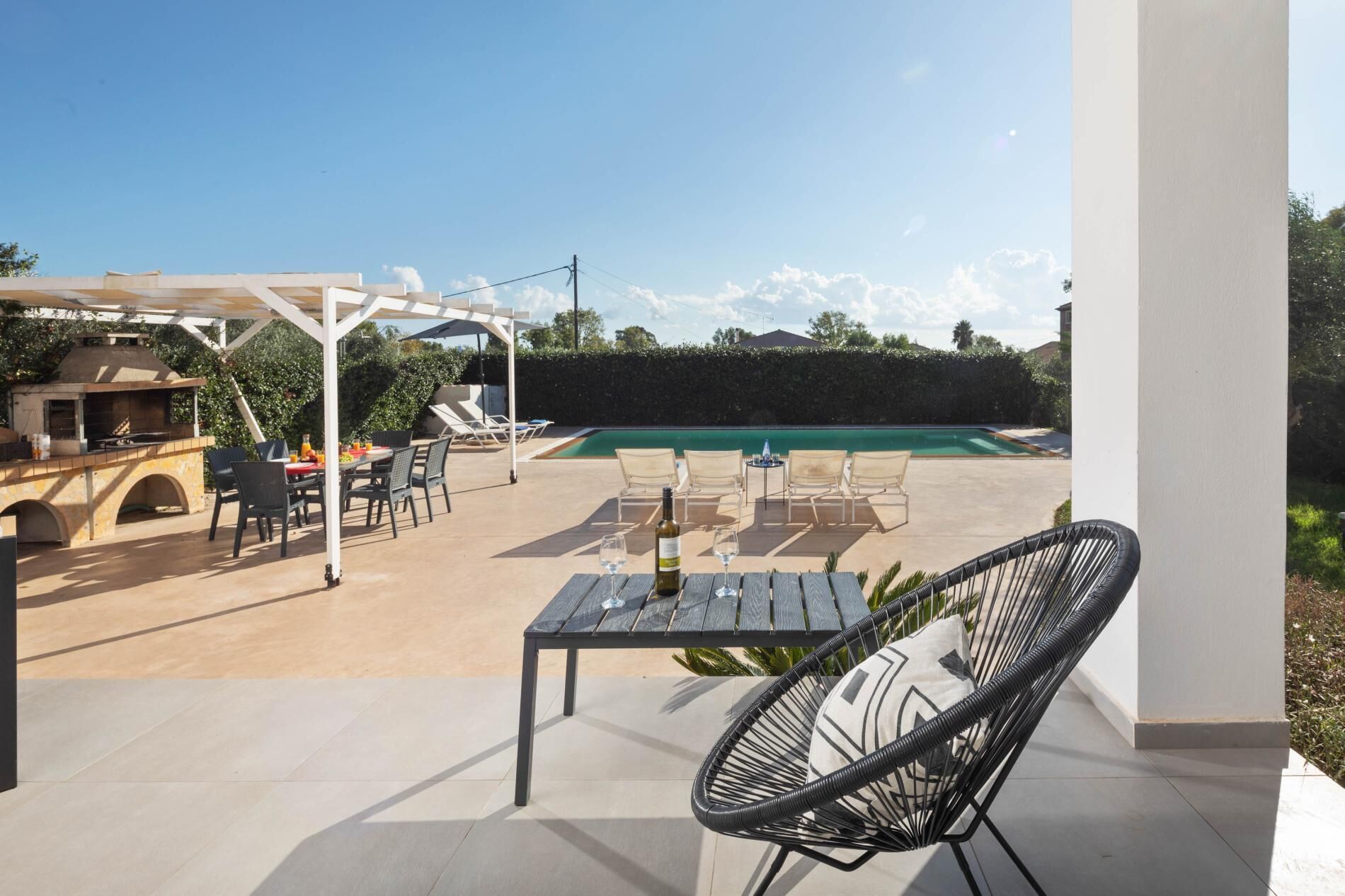 Une terrasse extérieure équipée d’un barbecue, d’un coin salon et d’une piscine.