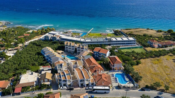 An aerial view of a coastal resort with multiple buildings, a swimming pool, and a view of the sea. - Dream House in Tragaki (Zakynthos)
