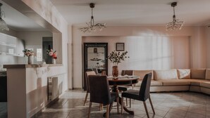 A modern living room with a dining area, featuring a round table, chairs, and a sofa. - Dream House in Tragaki (Zakynthos)