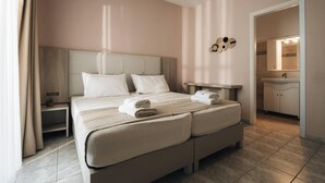 A double bed with a headboard, a bedside table, a nightstand, and a bathroom with a sink and mirror. - Dream House in Tragaki (Zakynthos)