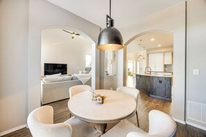 Una cocina moderna con armarios de madera, una isla central e iluminación colgante.