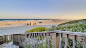 A beach view with a wooden walkway and a sandy beach. - Steps to Sand: Breezy Port Aransas Condo! (Port Aransas)