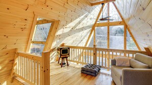 A wooden interior with a wooden TV on a tripod, a cushioned bench, and a sofa. - Steps to State Park! A-frame Cabin in Piney Creek (Piney Creek)
