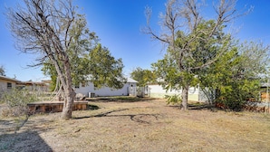 A residential area with houses, trees, and a dry grassy yard. - Near Hunting Grounds: Aspermont Home w/ Yard (Aspermont)