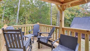 A wooden deck with Adirondack chairs and a table, surrounded by trees. - Big South Fork National River and Recreation Area (Oneida)