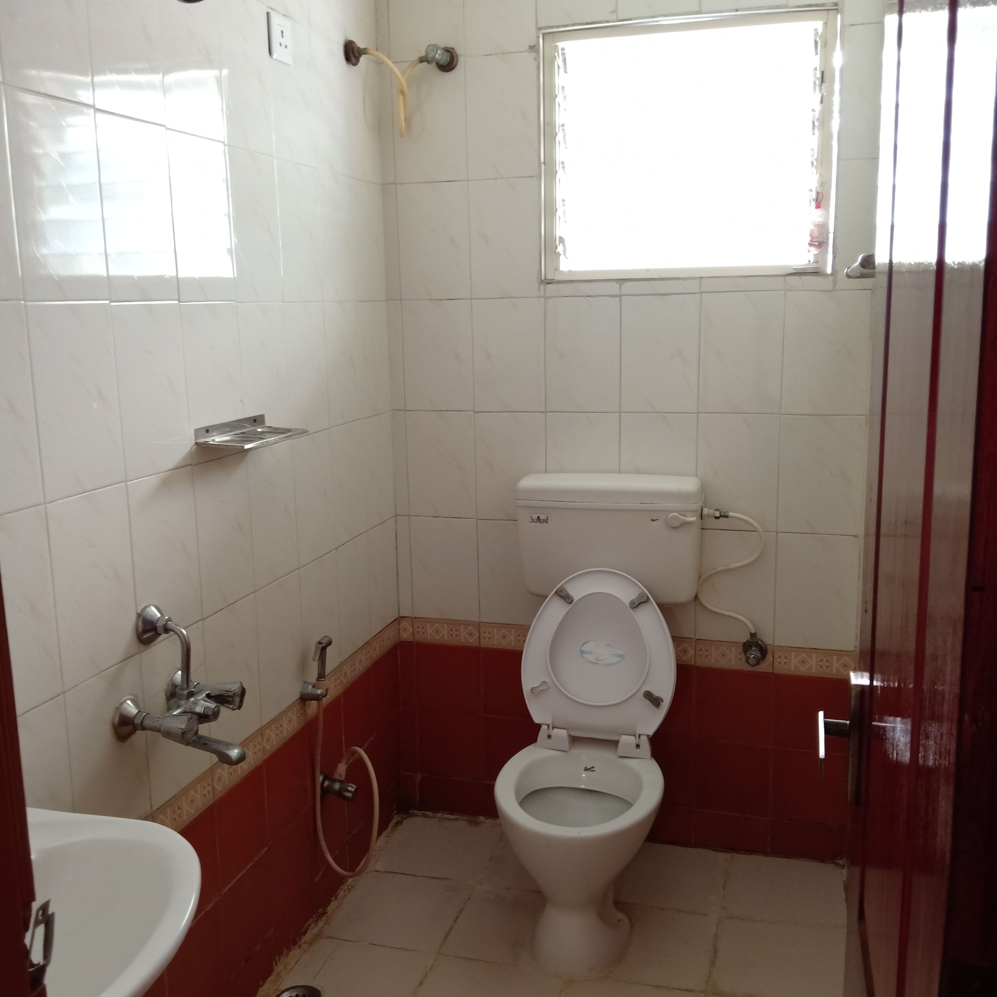 A bathroom with a toilet, sink, and shower.