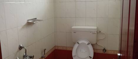 A bathroom with a toilet, sink, and shower.