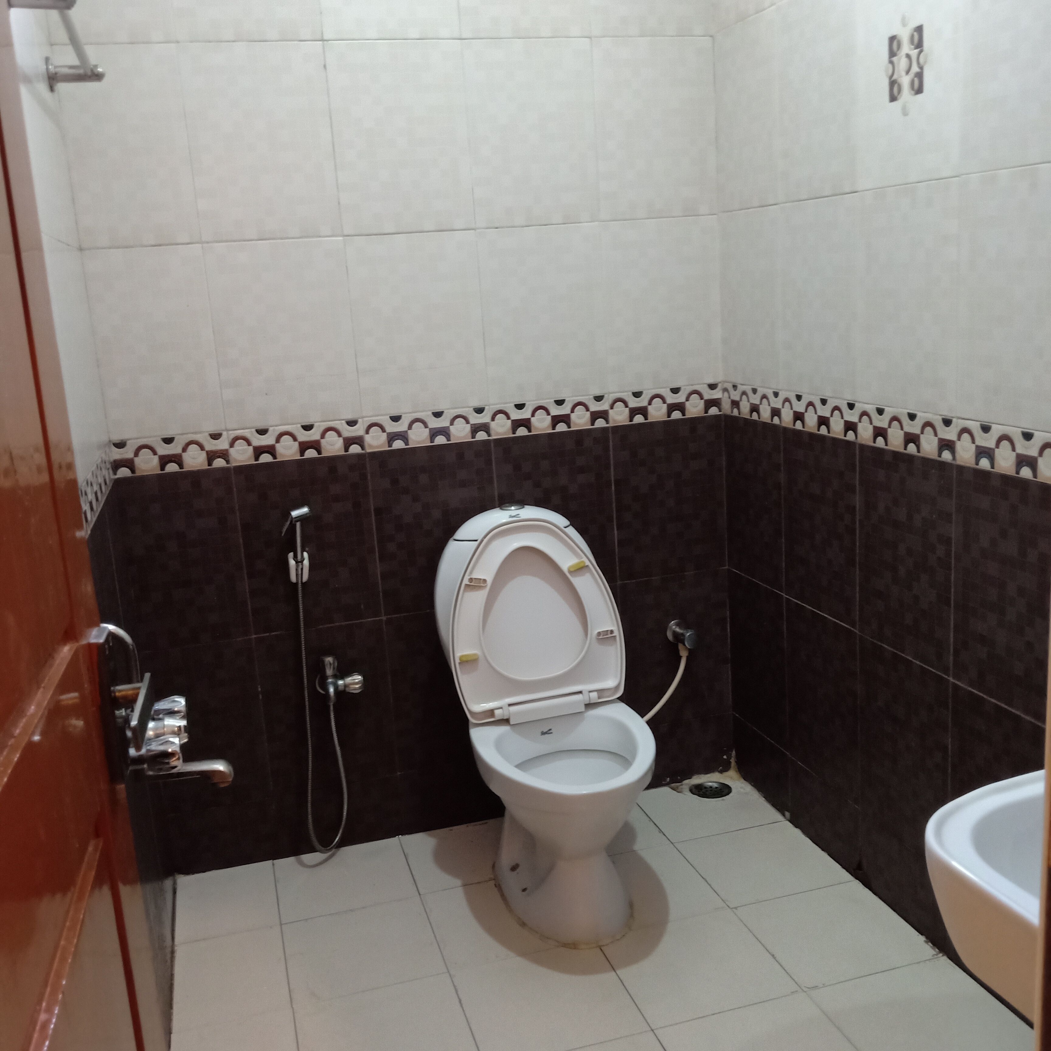 A bathroom with a toilet, a shower, and a sink.