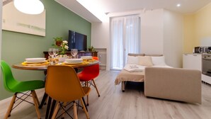 Un salon moderne comprenant un canapé, une table à manger avec des chaises et un coin cuisine.