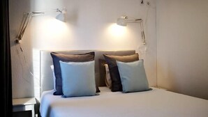 A hotel room with a bed, two bedside lamps, and two pillows. - Bulldog Inn Duna Parque Resorts & Hotels (Odemira)